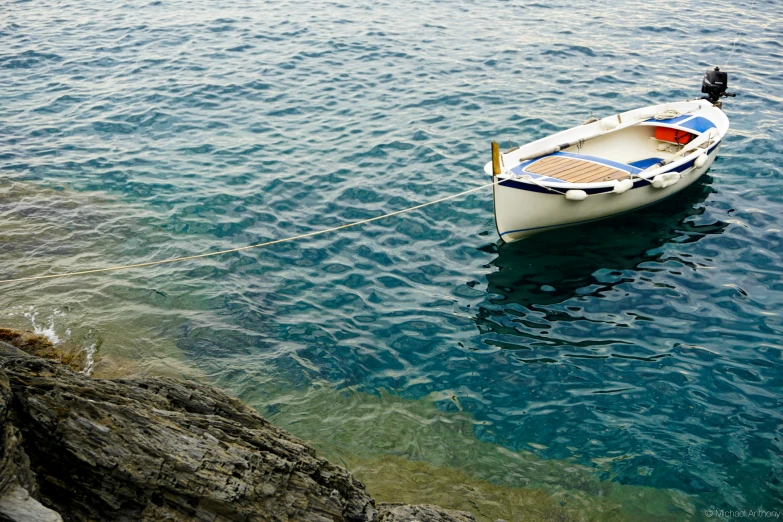 a small boat tied up to a rocky shore