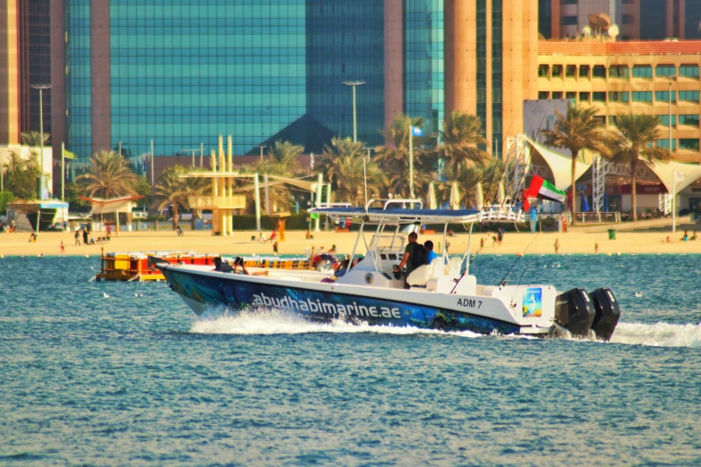 a boat traveling along the beach near a city