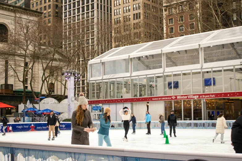 several people are skating on the ice at an outdoor rink