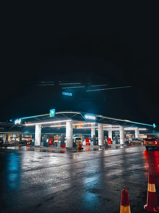 a large gas station with lights in the night