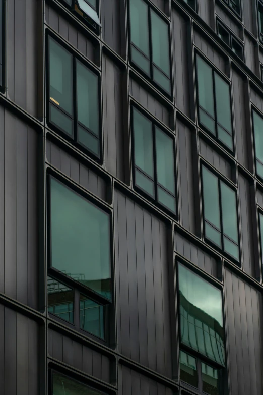 the windows of a building with green curtains