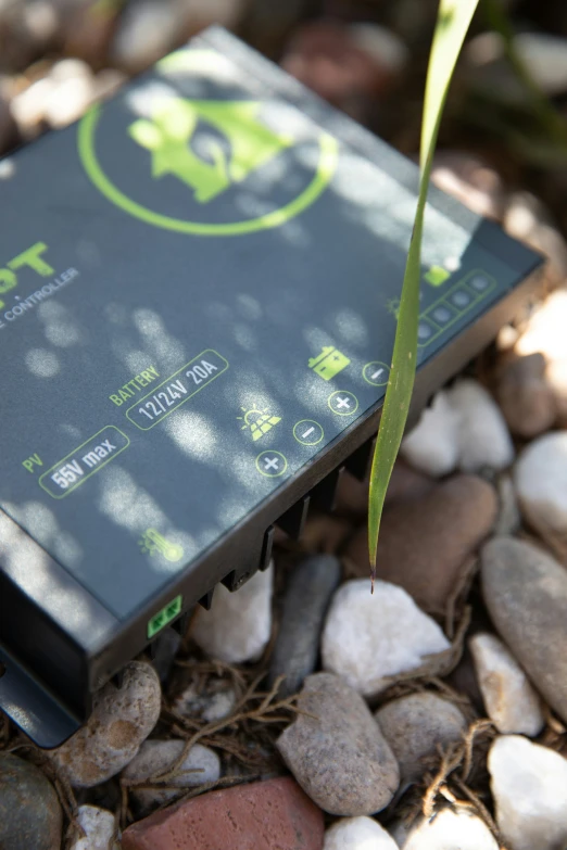 the electronic device is placed on some stones and has a leaf