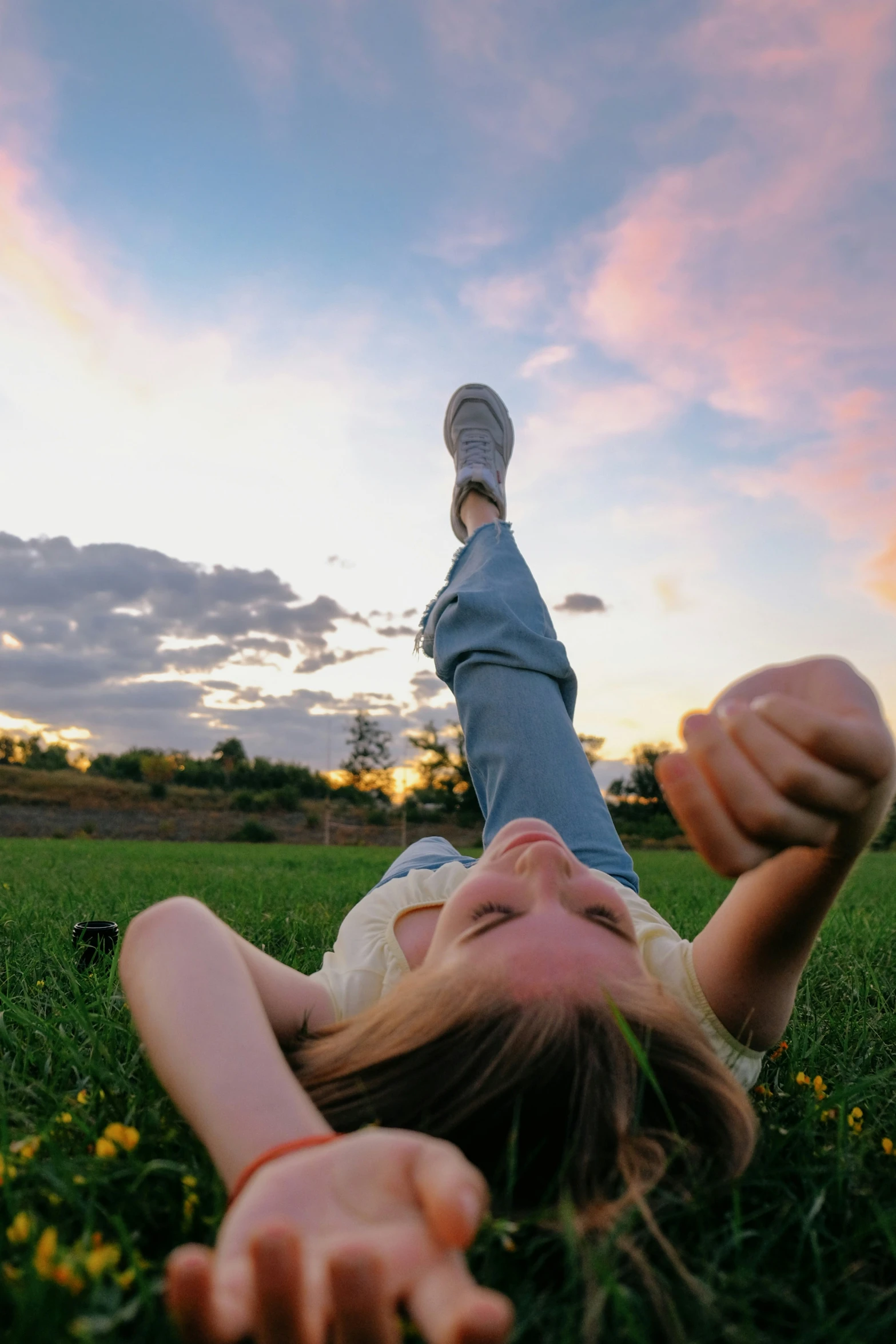 a woman lays down on the grass with her feet up