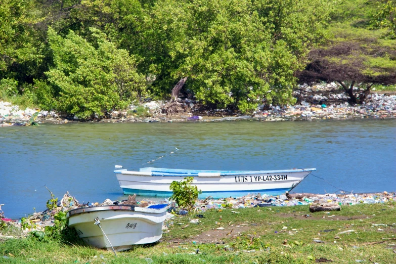 two boats on shore next to a large body of water