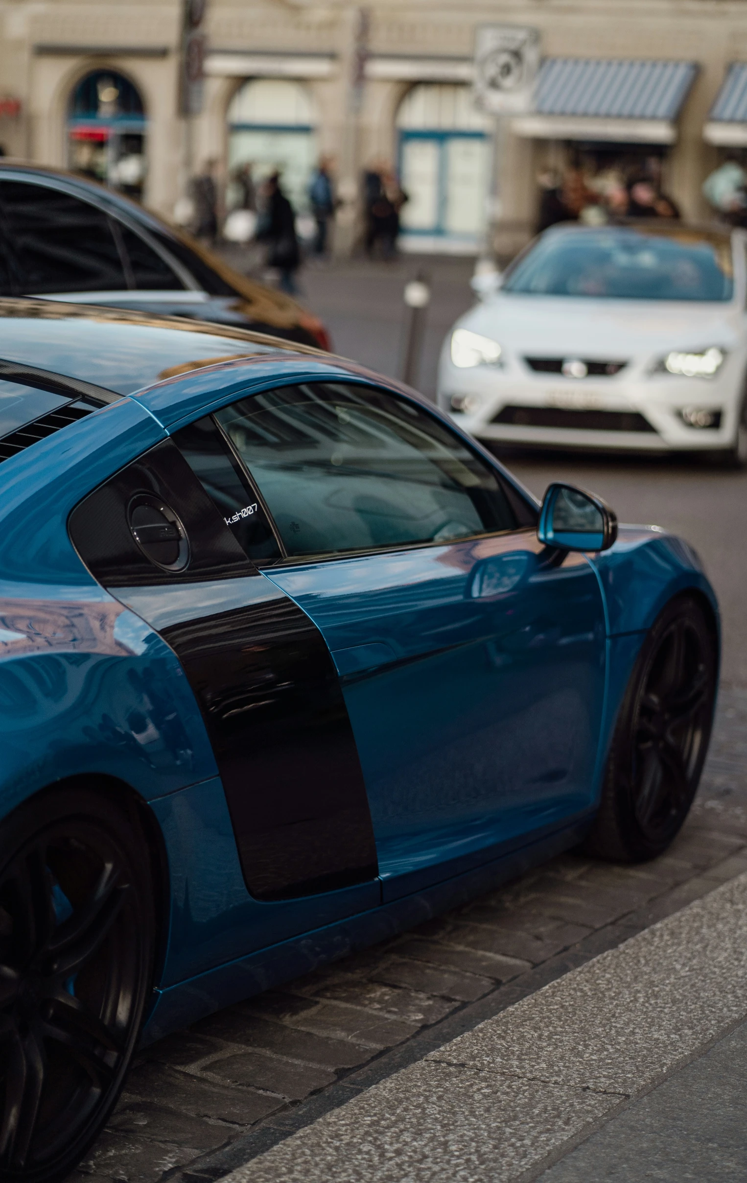 a blue and black sport car sits in the middle of the street