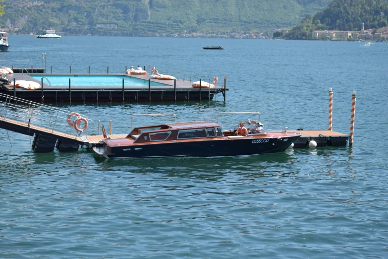 a boat sitting in the middle of a body of water with other boats nearby