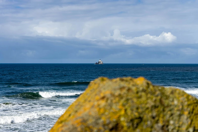 a boat sailing in the ocean on a cloudy day