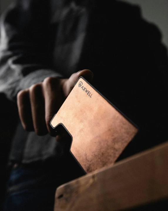 a person holding an credit card while sitting on a chair