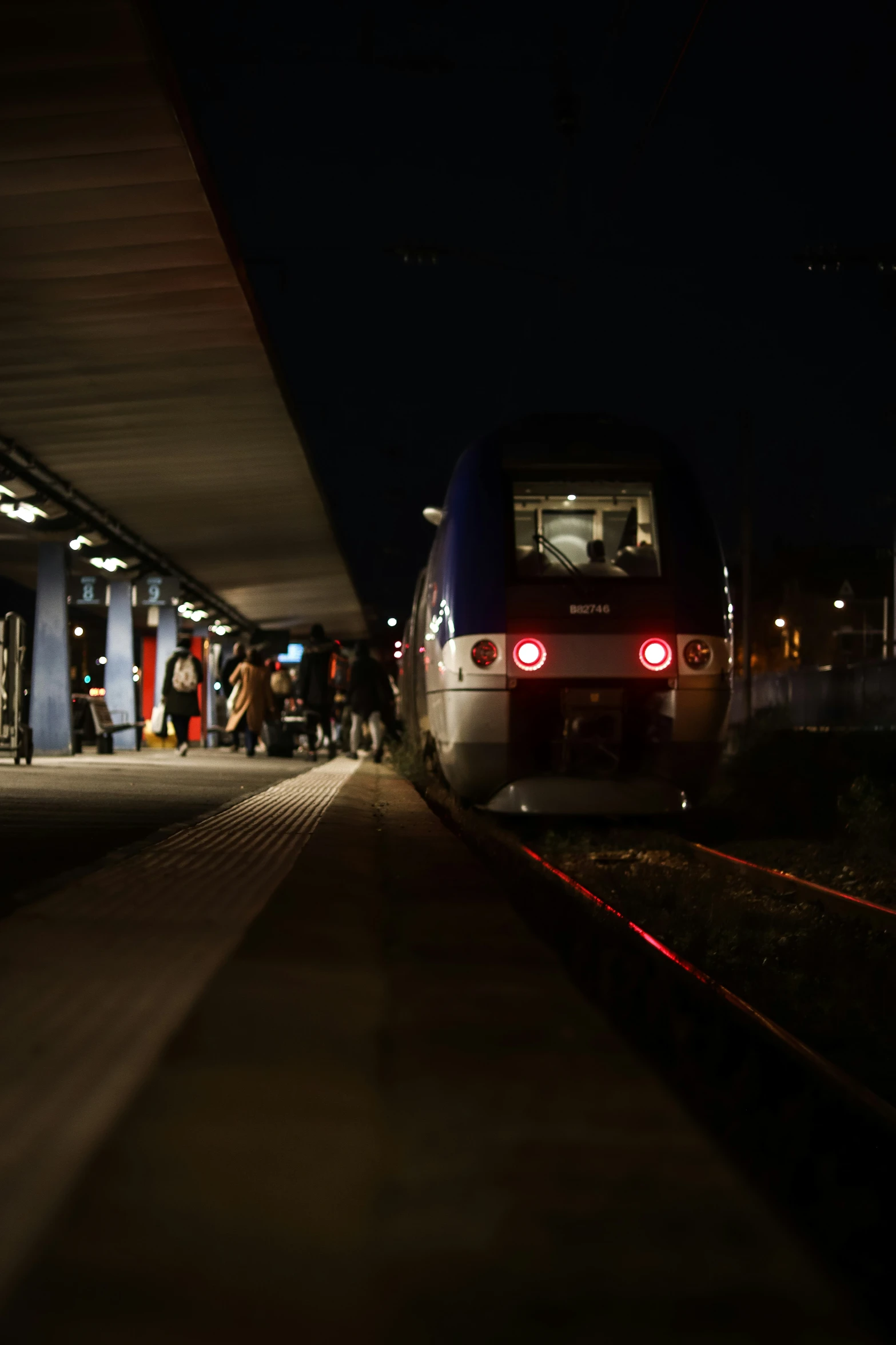 people standing next to the train at the station