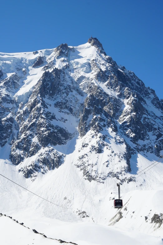 the mountains are covered with snow and a ski lift is attached