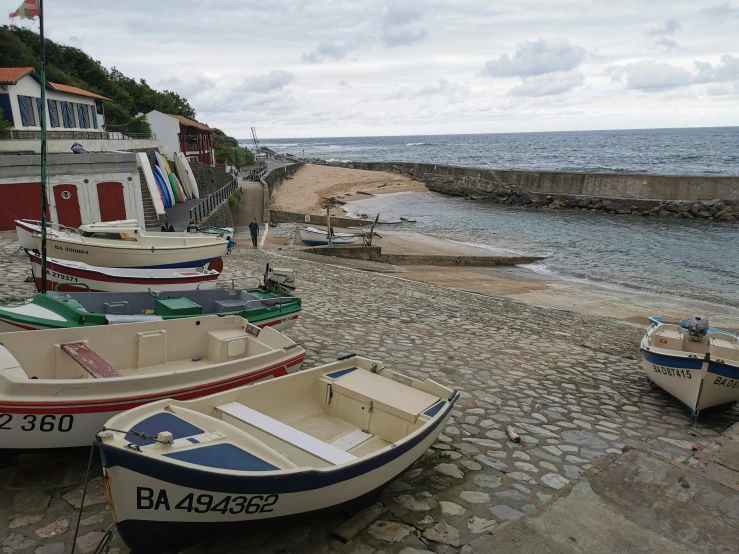 small boats sitting on the shore next to the ocean