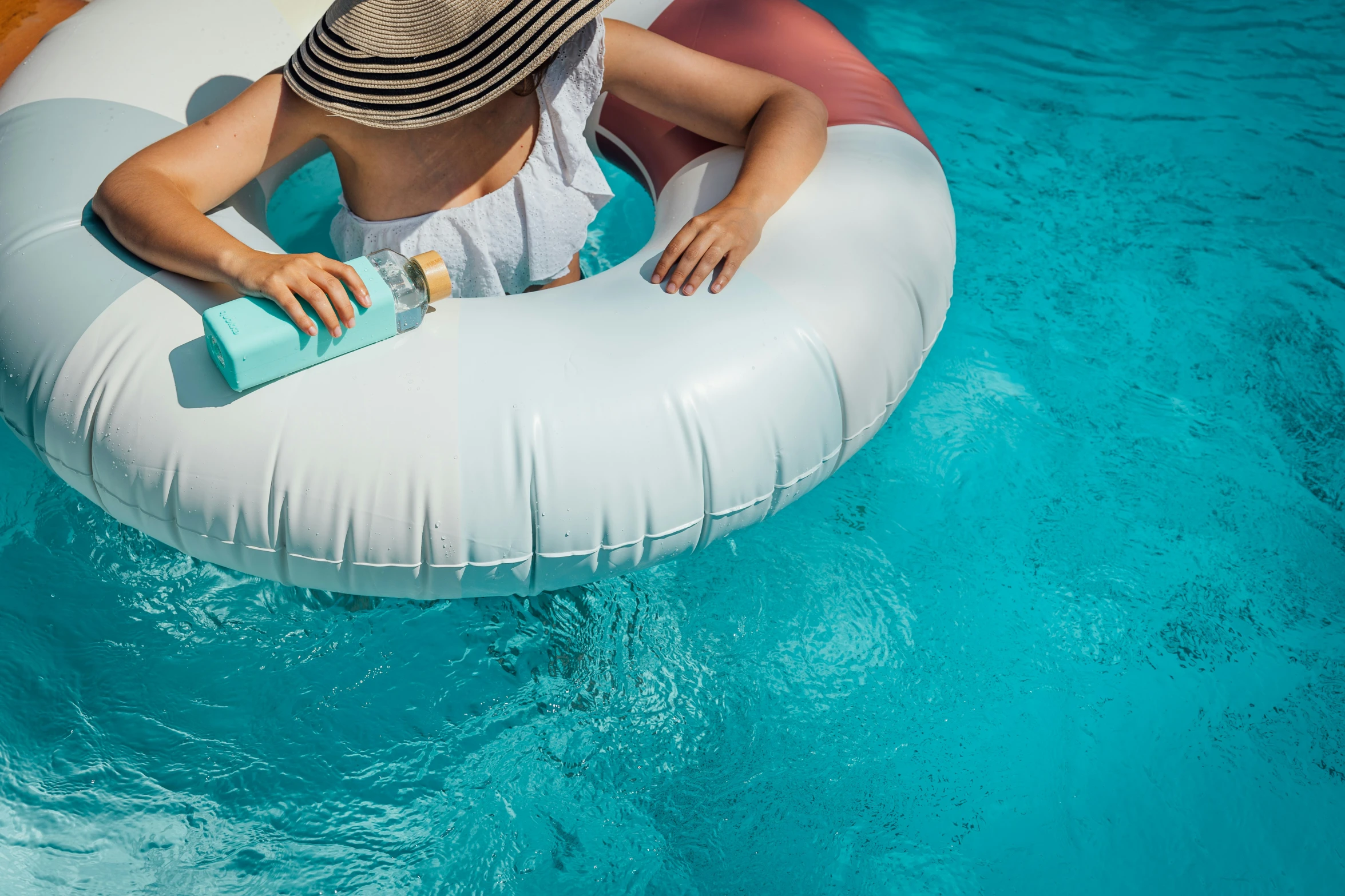 the woman is sitting on an inflatable raft in the pool