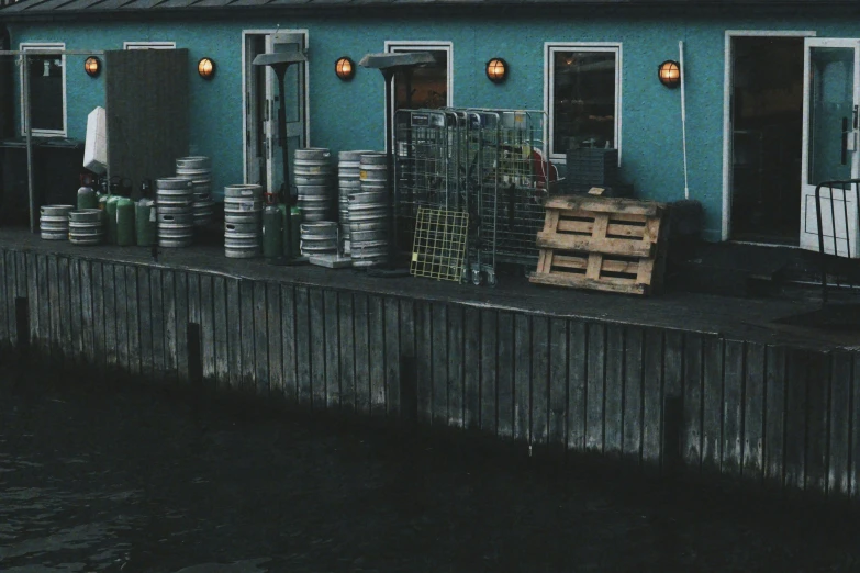 a house with various barrels outside by the water