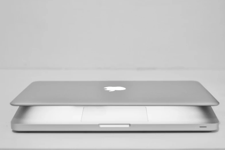 a silver apple laptop computer sitting on top of a table