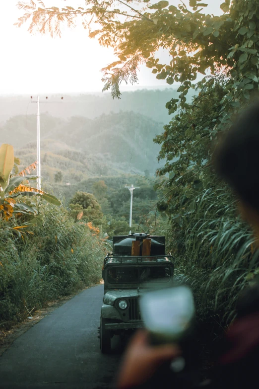 a jeep with luggage is stopped along a forest road