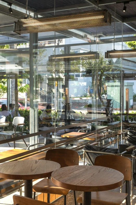 several wooden chairs and a table with large windows