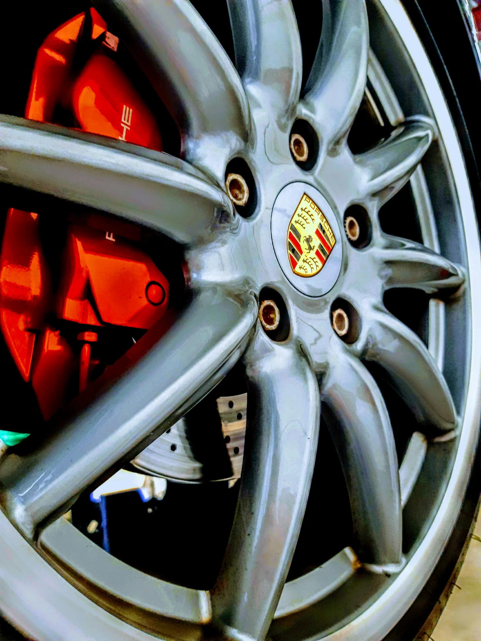 a porsche wheel with some red ke plates