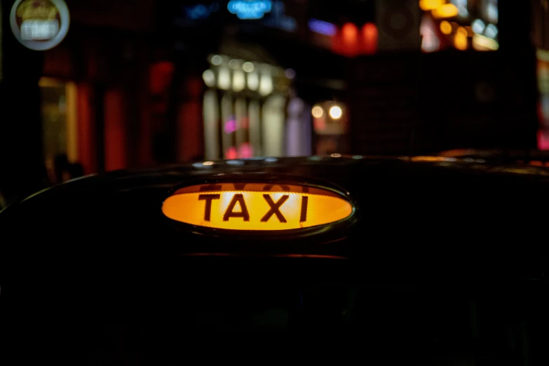 a taxi sign on a city street at night