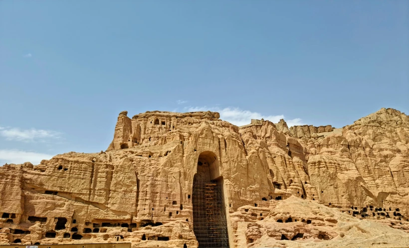 a large rock formation sitting below a blue sky