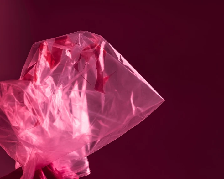 a pink bag of plastic wrap on top of a pink surface