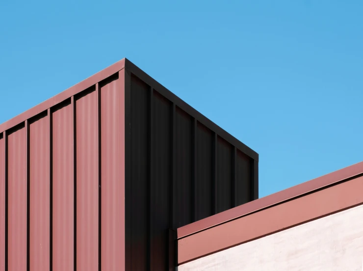 two red rooftops on the side of a building with a clear blue sky