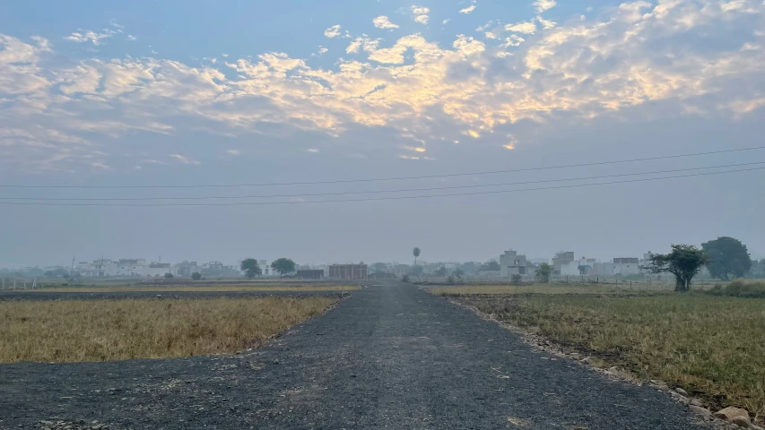 an empty road that is next to a field