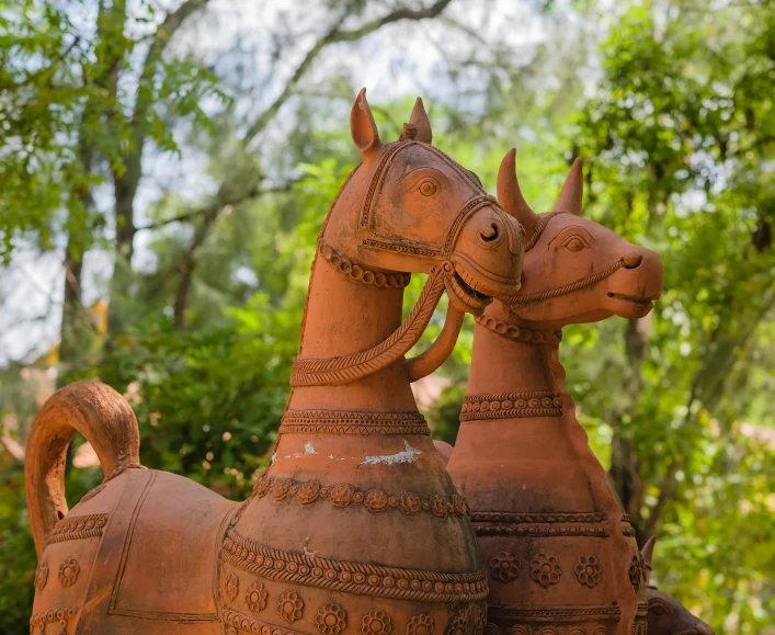 two clay animals statues are seen here