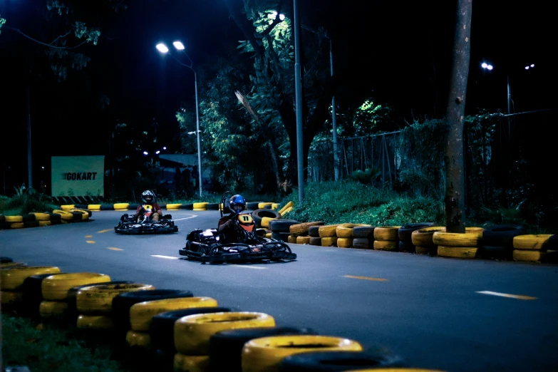 two men are riding down a curvy street at night