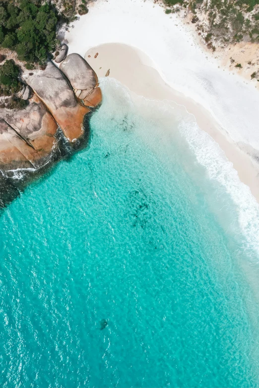 a boat floats through the blue water by the beach