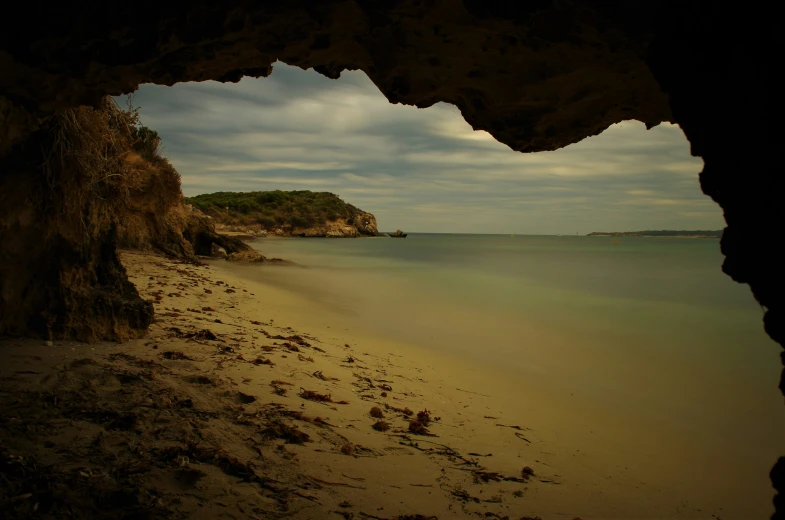 a beach view looking out the cave onto the water