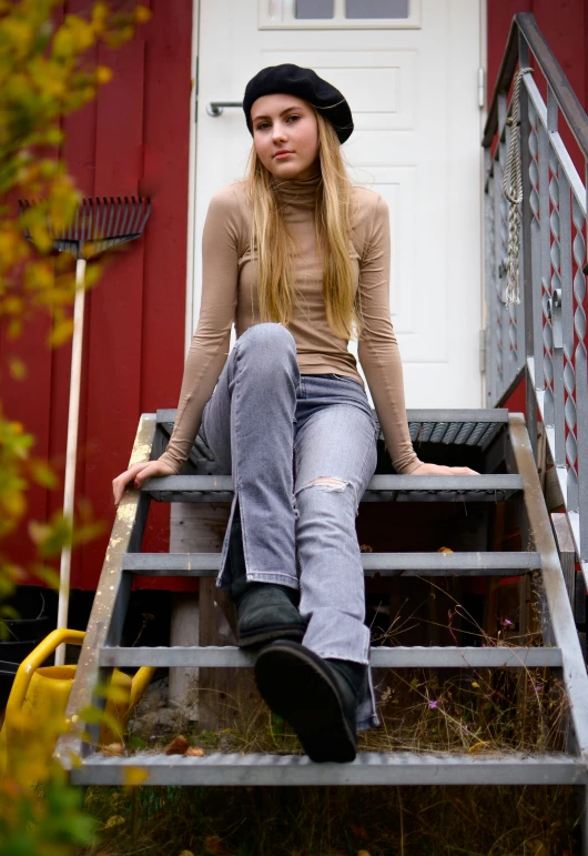 a girl sits on a set of steps outside