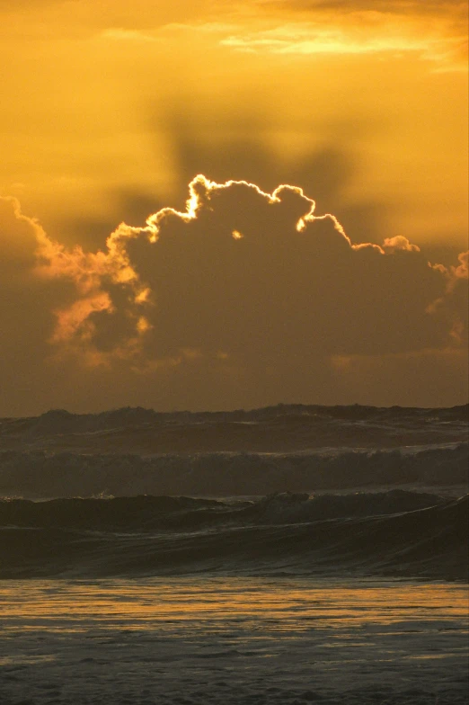 a lone surfer is out in the ocean looking at the sun