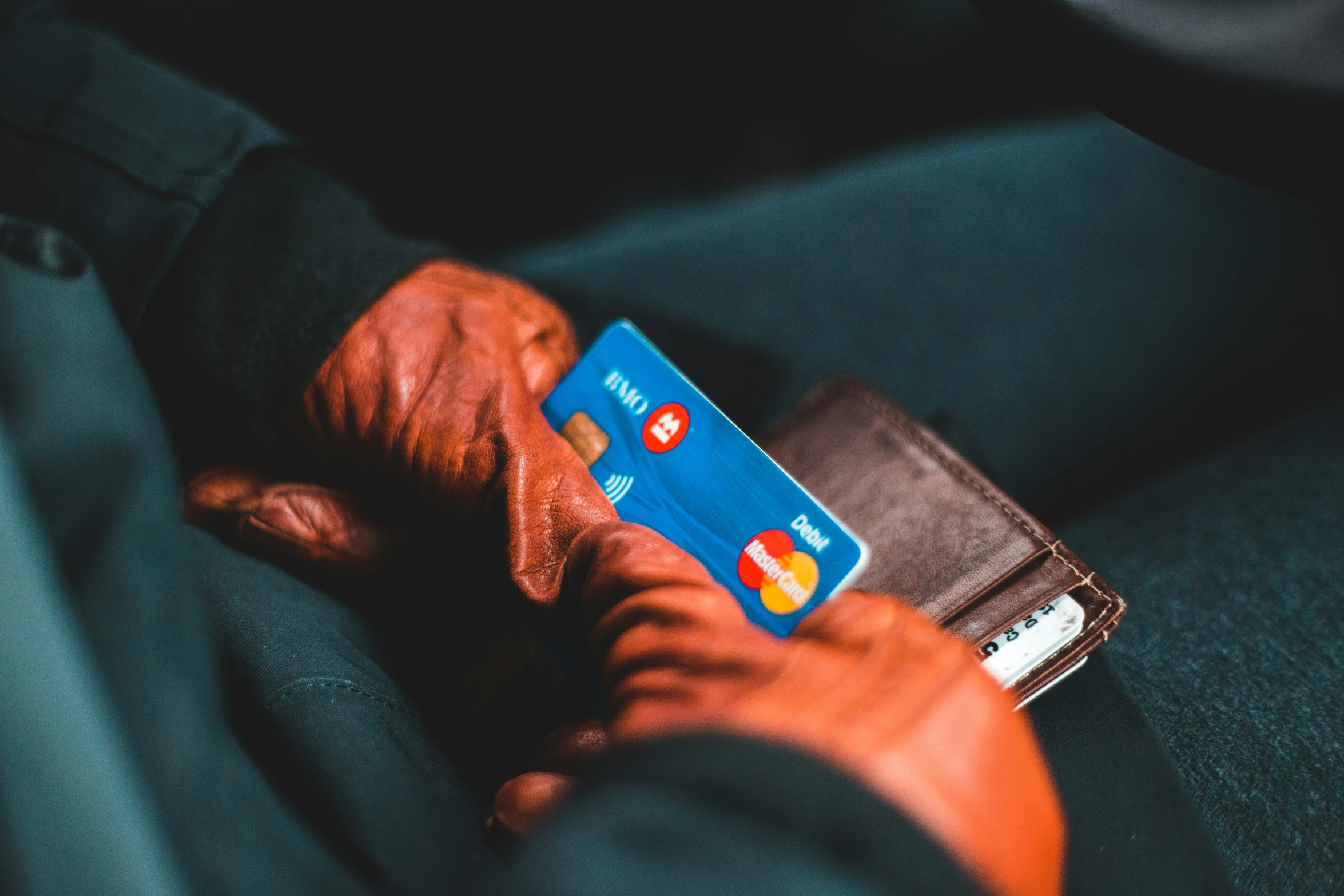 two hands holding a credit card and wallet