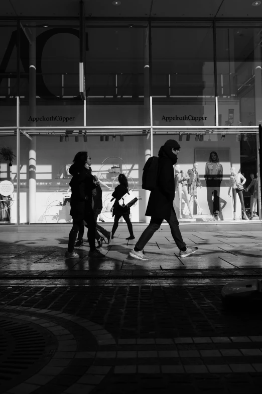 two people and a child walking across a sidewalk