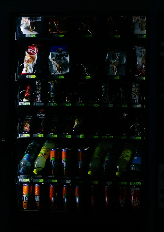 a vending machine at night with soda and pepsi bottles on display