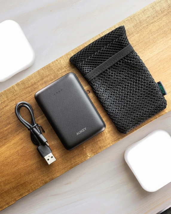 a laptop and power strip sitting on a wooden desk