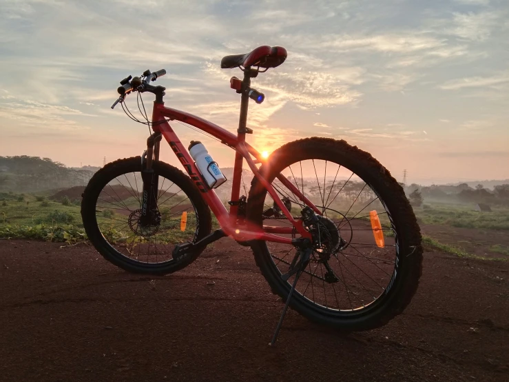 there is a red bicycle with an orange bike stand on the side of the road