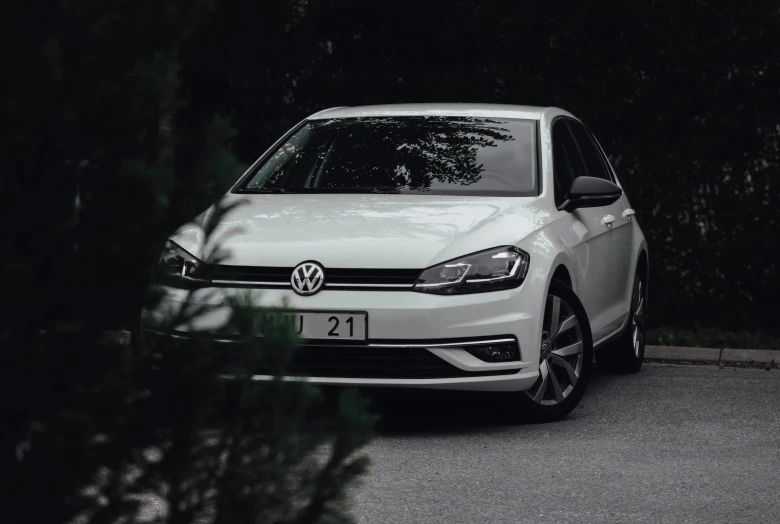 white volkswagen is driving down a road in the dark