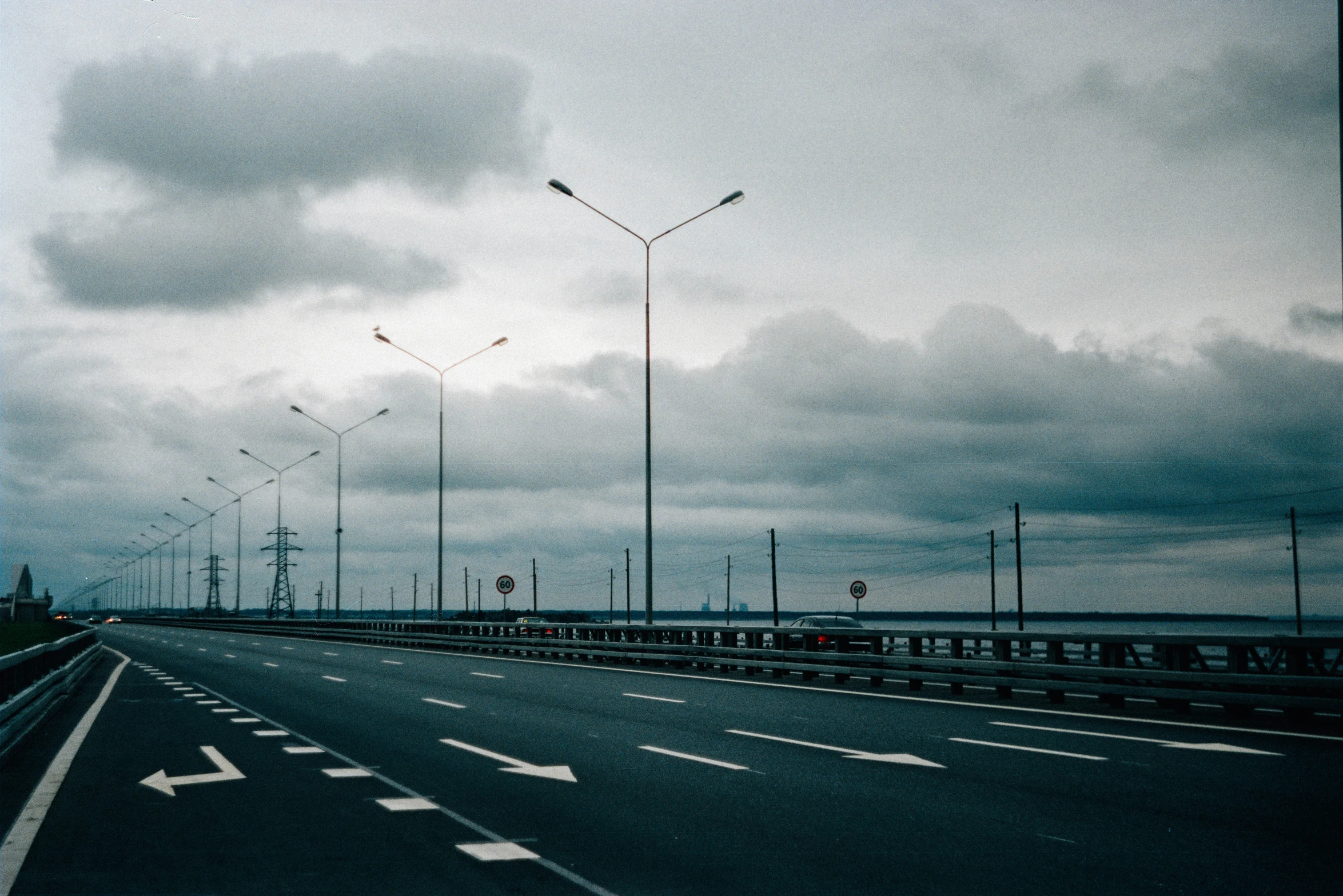 an empty street with traffic lights and a freeway on it