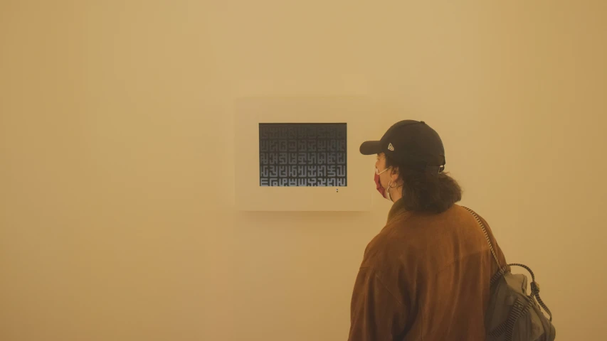 the person is looking at the screen on the wall