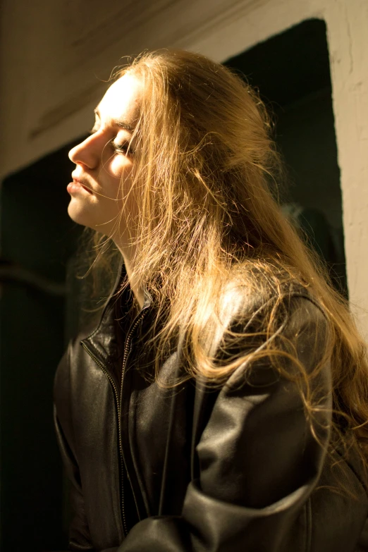 a woman in a black jacket is staring off to the side