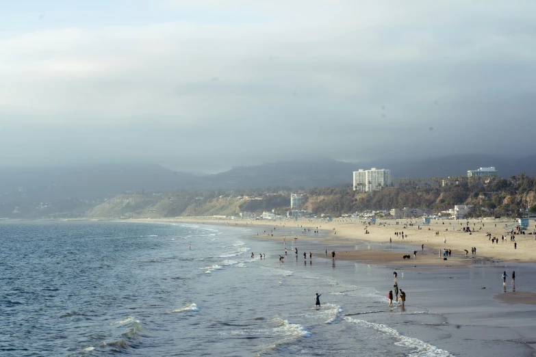 people playing in the sand and water at a beach