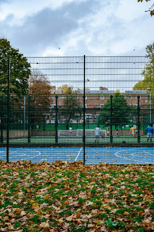 an orange park bench sitting next to a large fence