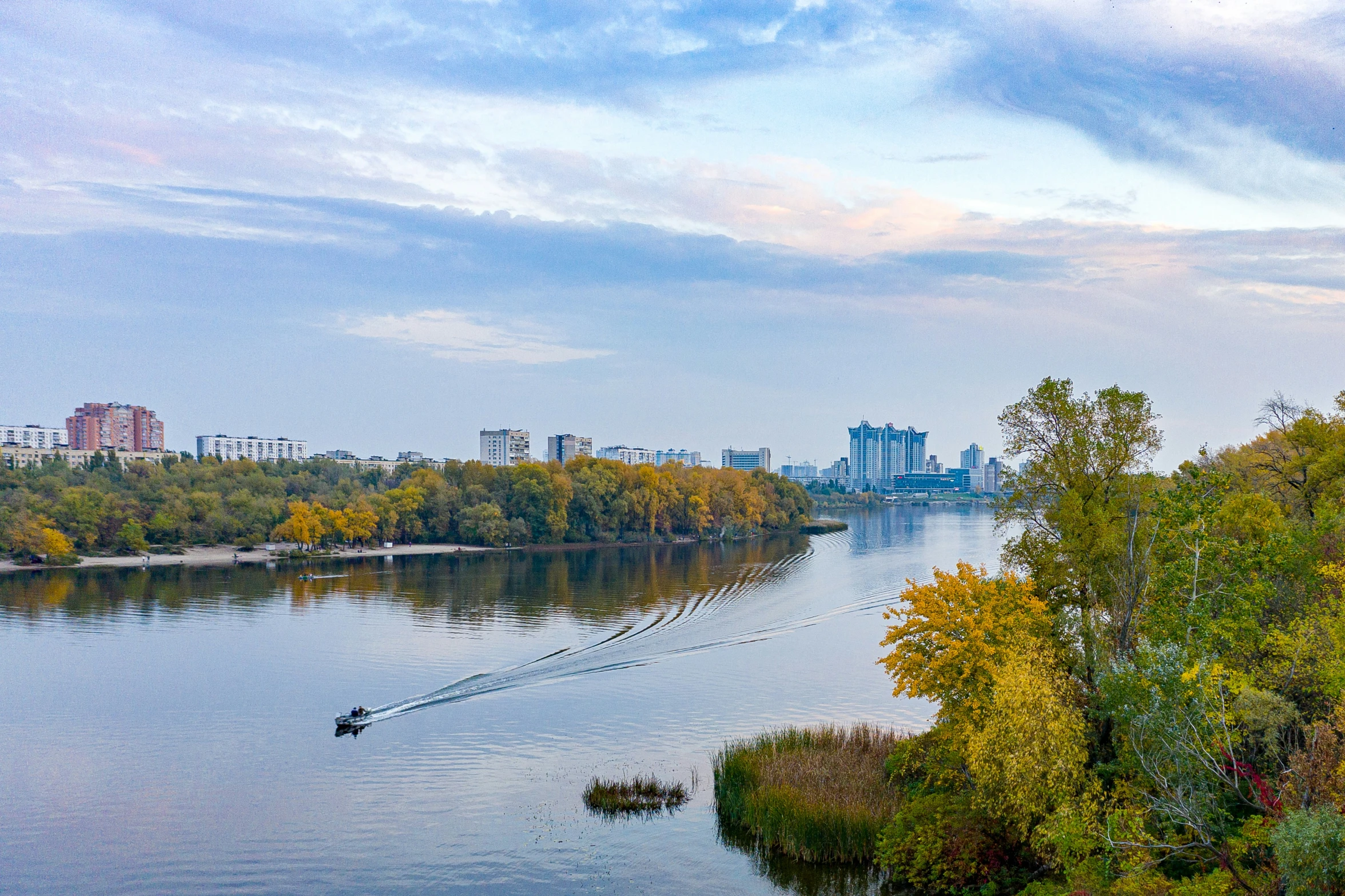 a body of water surrounded by green trees and buildings