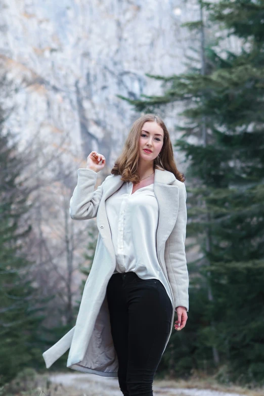 the young woman is walking through a wooded area