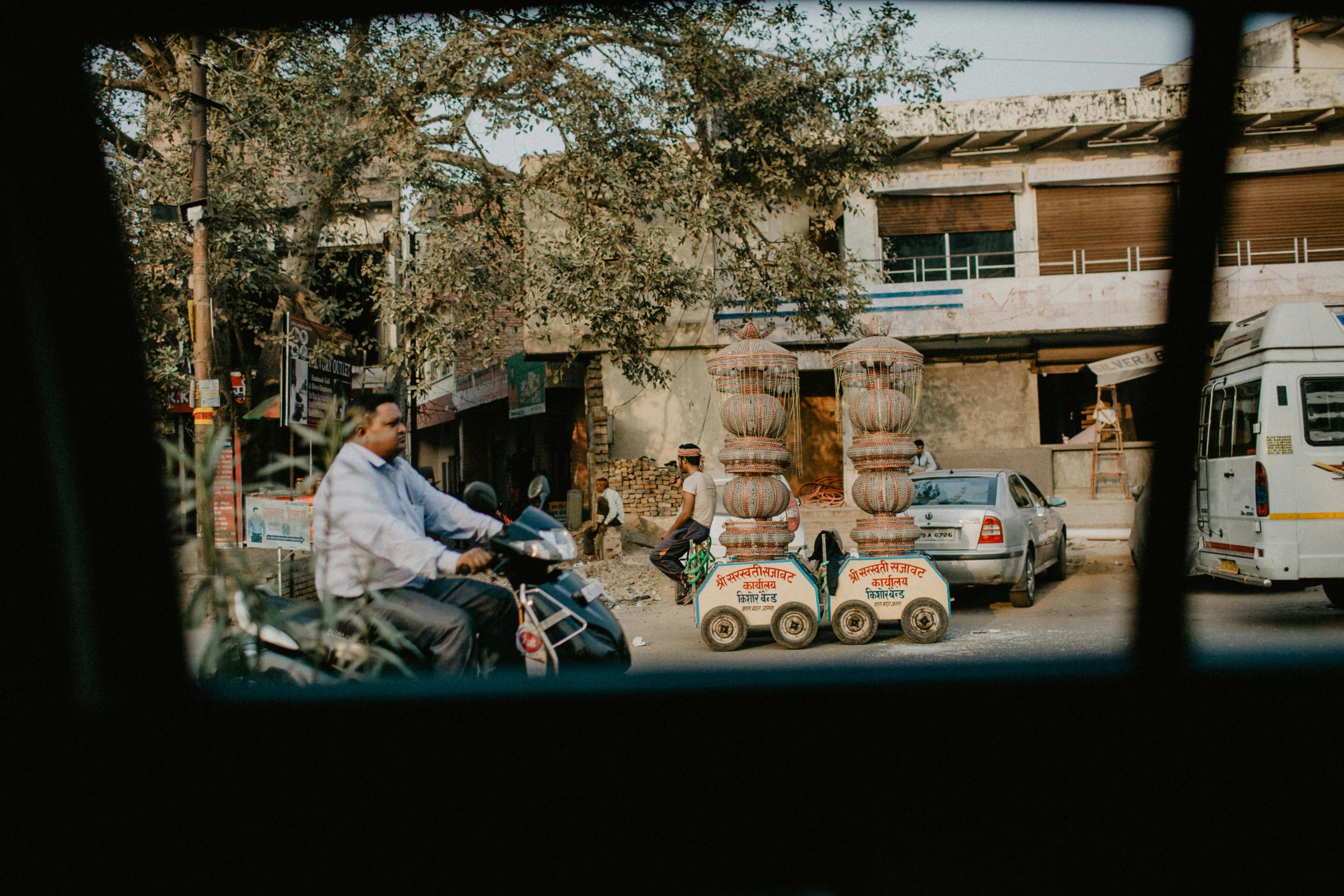 a street scene with vehicles and people on a motorcycle