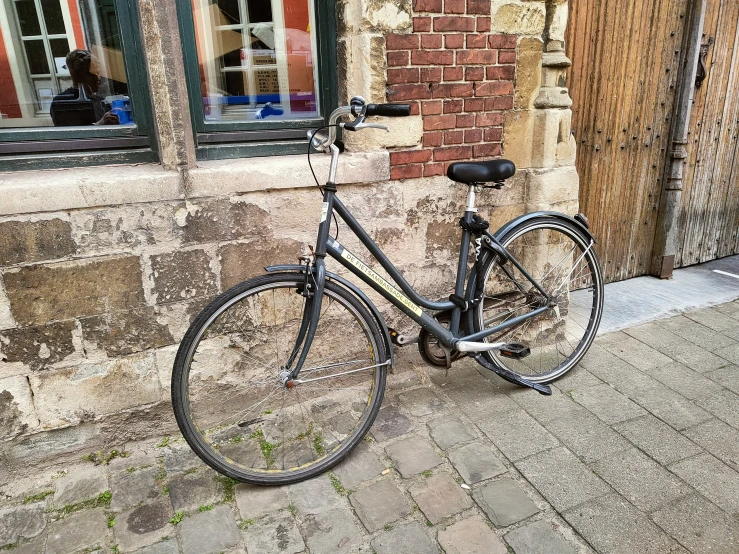 a bicycle parked next to a brick building