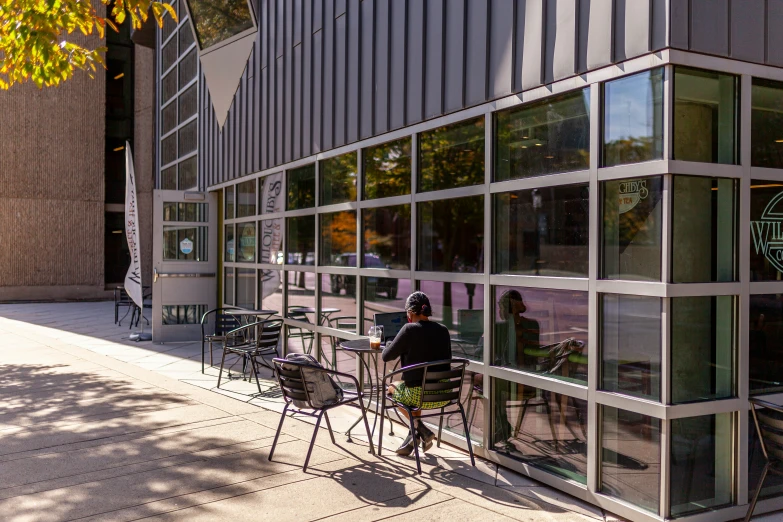 there are people sitting at table outside of the building