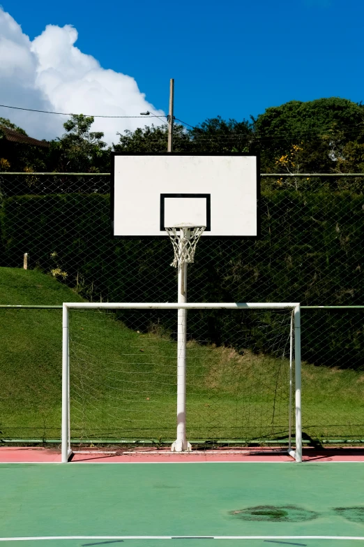 a white basketball net is installed at an outdoor basketball court