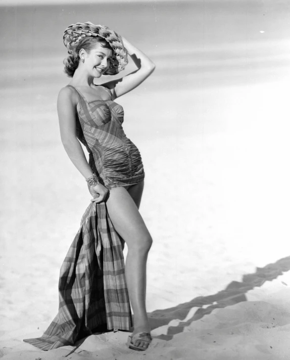 a woman posing in a sheer dress and hat